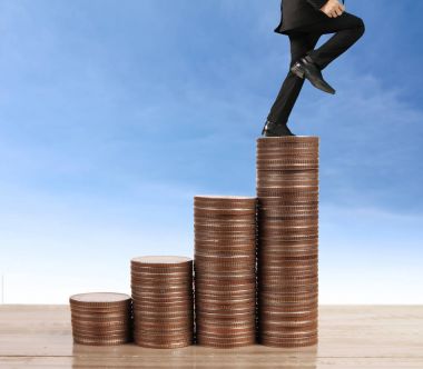 İşadamı yürümek sikkelerin yığın üzerinde başarı yetişen 