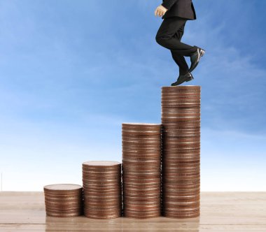 İşadamı yürümek sikkelerin yığın üzerinde başarı yetişen 