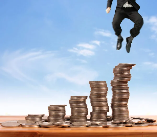 İşadamı yürümek sikkelerin yığın üzerinde başarı yetişen 