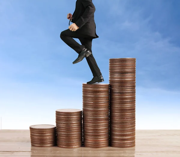 Businessman walk on stack of coins which grows success — Stock Photo, Image