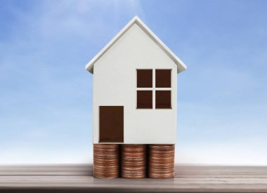 Küçük tatil evi ayakta yığınları sikkeler üzerinde