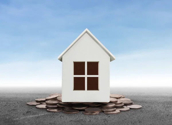Small house standing on stacks of coins