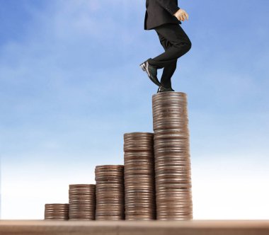 İşadamı, başarı ve yatırımı artıran madeni paraların üzerinde yürüyor
