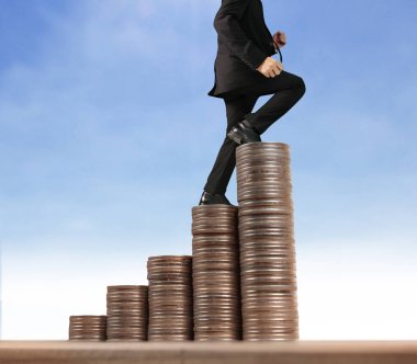 İşadamı, başarı ve yatırımı artıran madeni paraların üzerinde yürüyor