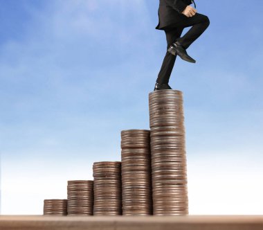 İşadamı, başarı ve yatırımı artıran madeni paraların üzerinde yürüyor
