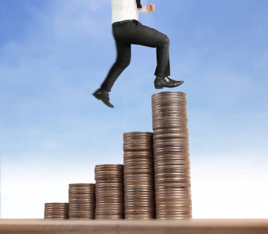 İşadamı, başarı ve yatırımı artıran madeni paraların üzerinde yürüyor
