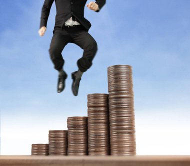 İşadamı, başarı ve yatırımı artıran madeni paraların üzerinde yürüyor