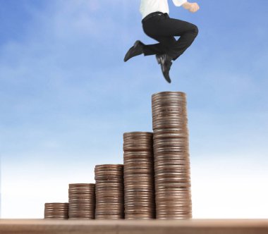İşadamı, başarı ve yatırımı artıran madeni paraların üzerinde yürüyor