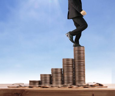 İşadamı, başarı ve yatırımı artıran madeni paraların üzerinde yürüyor