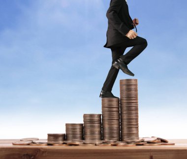 İşadamı, başarı ve yatırımı artıran madeni paraların üzerinde yürüyor