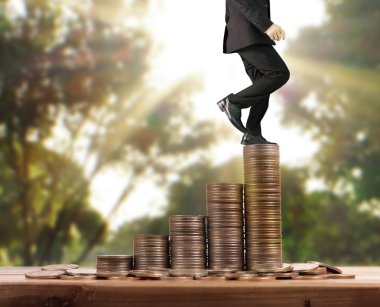 İşadamı, başarı ve yatırımı artıran madeni paraların üzerinde yürüyor
