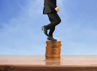 İşadamı yürümek sikkelerin yığın üzerinde başarı yetişen 