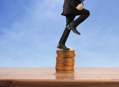 İşadamı, başarı ve yatırımı artıran madeni paraların üzerinde yürüyor