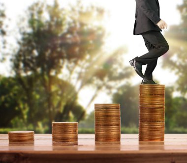 İşadamı, başarı ve yatırımı artıran madeni paraların üzerinde yürüyor