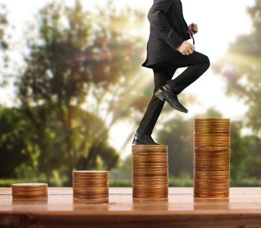 İşadamı yürümek sikkelerin yığın üzerinde başarı yetişen 