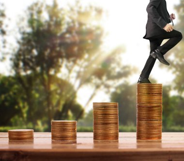 İşadamı, başarı ve yatırımı artıran madeni paraların üzerinde yürüyor