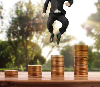 İşadamı, başarı ve yatırımı artıran madeni paraların üzerinde yürüyor