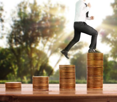 İşadamı, başarı ve yatırımı artıran madeni paraların üzerinde yürüyor