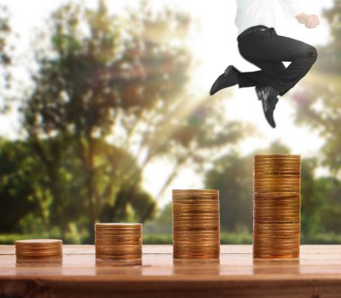 İşadamı, başarı ve yatırımı artıran madeni paraların üzerinde yürüyor