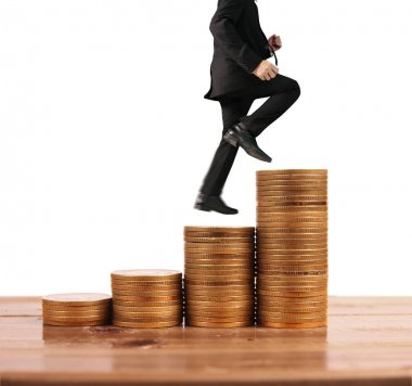 İşadamı, başarı ve yatırımı artıran madeni paraların üzerinde yürüyor