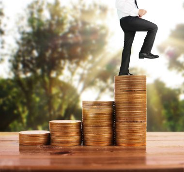 İşadamı, başarı ve yatırımı artıran madeni paraların üzerinde yürüyor