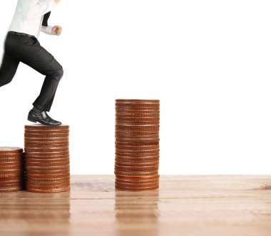 İşadamı, başarı ve yatırımı artıran madeni paraların üzerinde yürüyor