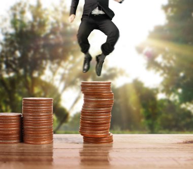 İşadamı, başarı ve yatırımı artıran madeni paraların üzerinde yürüyor