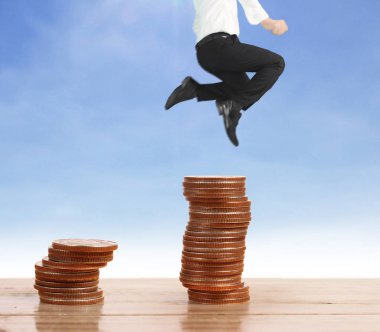 İşadamı, başarı ve yatırımı artıran madeni paraların üzerinde yürüyor