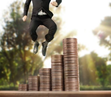 İşadamı, başarı ve yatırımı artıran madeni paraların üzerinde yürüyor