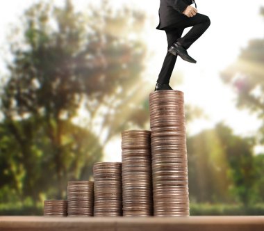 İşadamı, başarı ve yatırımı artıran madeni paraların üzerinde yürüyor