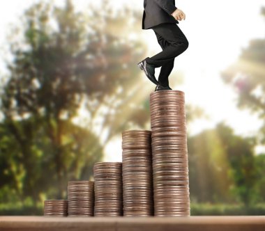 İşadamı, başarı ve yatırımı artıran madeni paraların üzerinde yürüyor