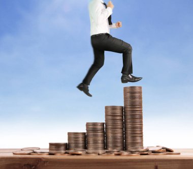 İşadamı, başarı ve yatırımı artıran madeni paraların üzerinde yürüyor