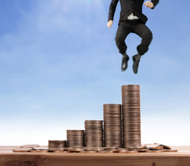 İşadamı, başarı ve yatırımı artıran madeni paraların üzerinde yürüyor