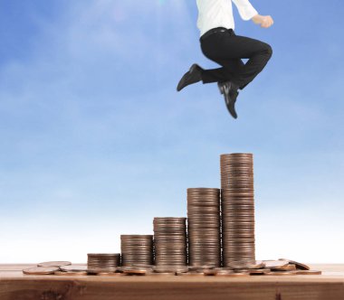 İşadamı, başarı ve yatırımı artıran madeni paraların üzerinde yürüyor