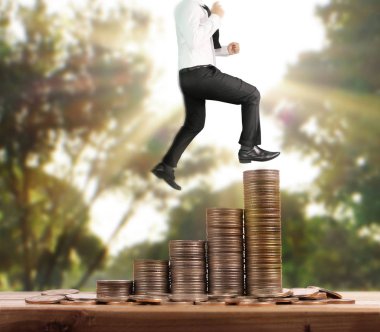 İşadamı, başarı ve yatırımı artıran madeni paraların üzerinde yürüyor