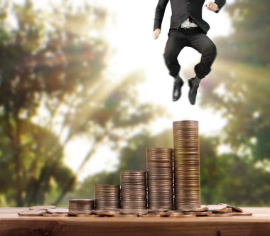 İşadamı yürümek sikkelerin yığın üzerinde başarı yetişen 