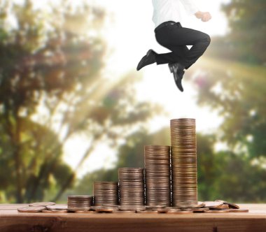 İşadamı yürümek sikkelerin yığın üzerinde başarı yetişen 