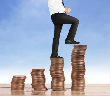 İşadamı, başarı ve yatırımı artıran madeni paraların üzerinde yürüyor