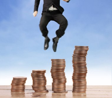 İşadamı, başarı ve yatırımı artıran madeni paraların üzerinde yürüyor