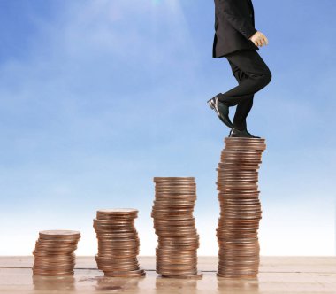 İşadamı, başarı ve yatırımı artıran madeni paraların üzerinde yürüyor