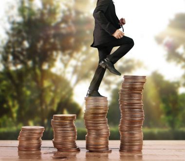 İşadamı yürümek sikkelerin yığın üzerinde başarı yetişen 