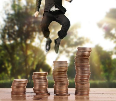 İşadamı, başarı ve yatırımı artıran madeni paraların üzerinde yürüyor