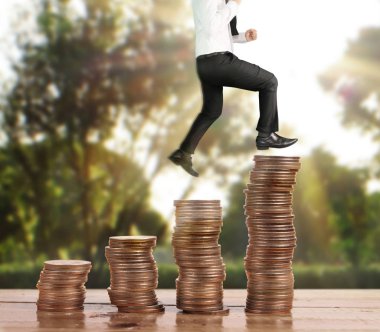 İşadamı yürümek sikkelerin yığın üzerinde başarı yetişen 