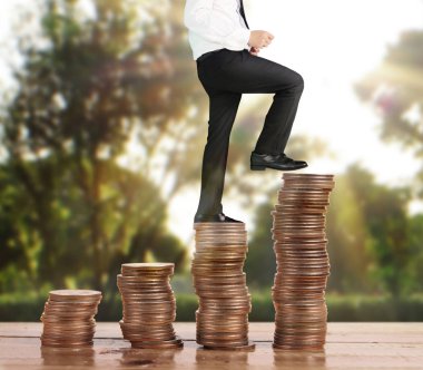 İşadamı yürümek sikkelerin yığın üzerinde başarı yetişen 