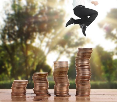 İşadamı, başarı ve yatırımı artıran madeni paraların üzerinde yürüyor