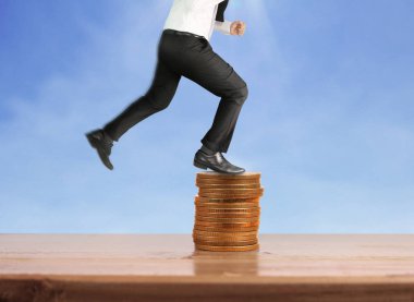 İşadamı yürümek sikkelerin yığın üzerinde başarı yetişen 