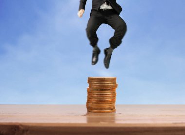 İşadamı yürümek sikkelerin yığın üzerinde başarı yetişen 