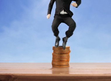 İşadamı yürümek sikkelerin yığın üzerinde başarı yetişen 