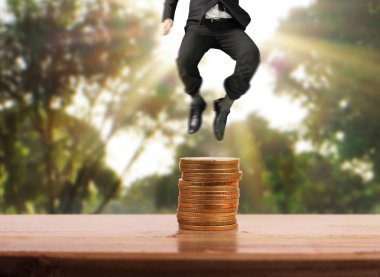 İşadamı, başarı ve yatırımı artıran madeni paraların üzerinde yürüyor