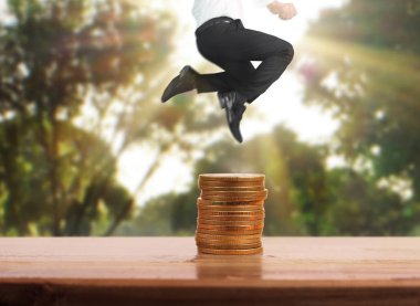 İşadamı, başarı ve yatırımı artıran madeni paraların üzerinde yürüyor